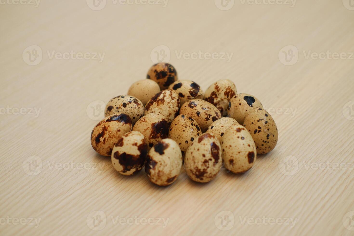 Quail eggs on a wooden background. Close-up, selective focus. photo