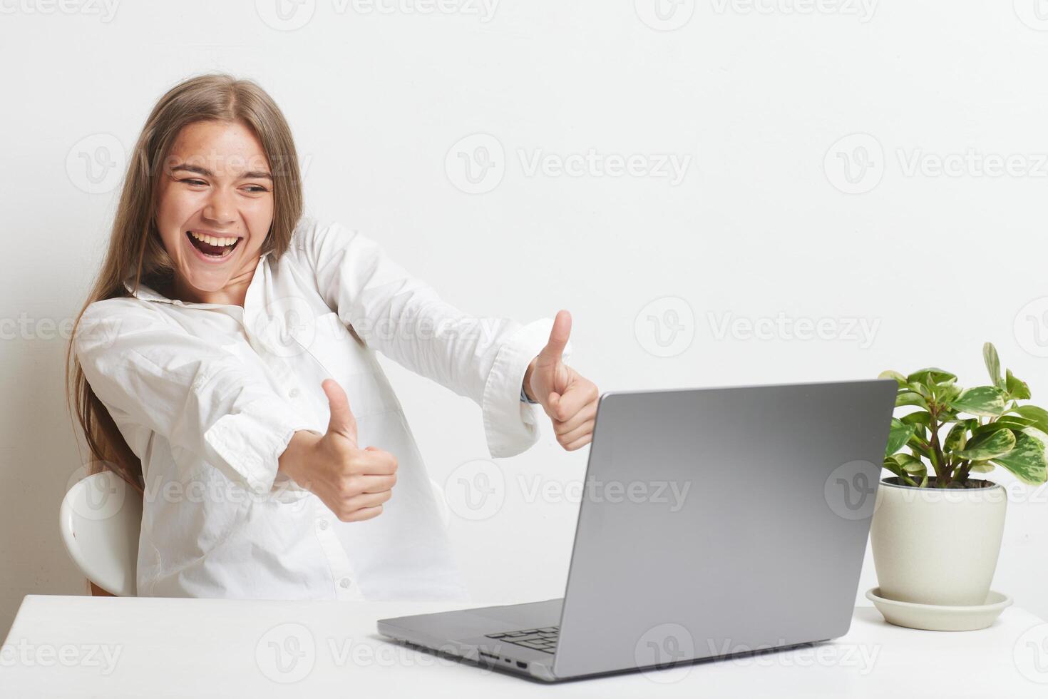 happy girl with laptop rejoices at successful work while working in the office, success at work photo