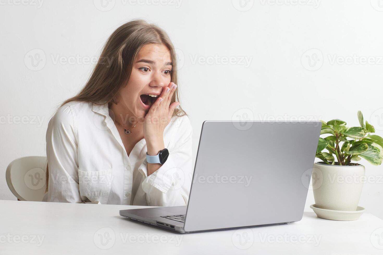 happy girl with laptop rejoices at successful work while working in the office, success at work photo