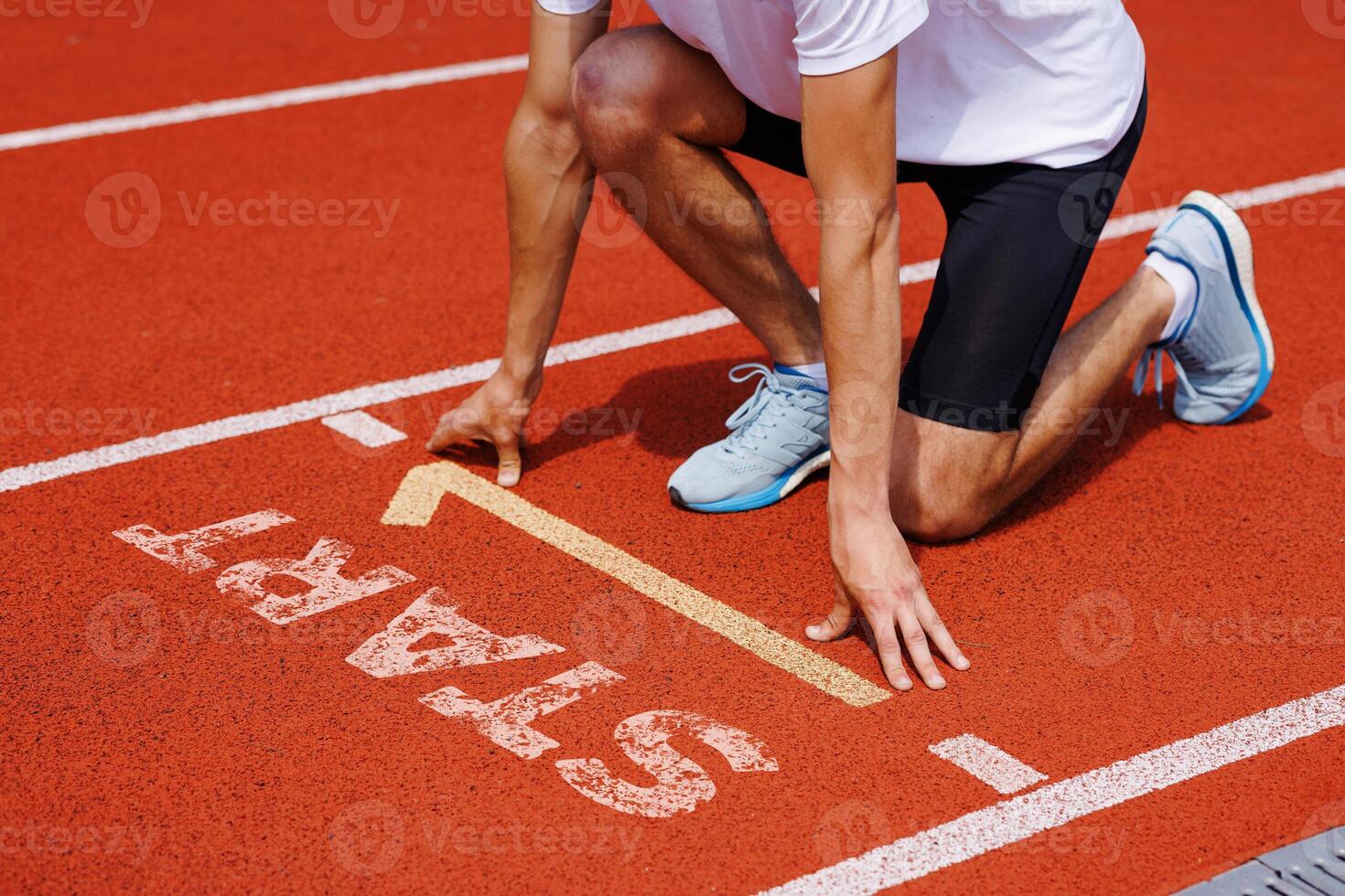 Athlete at starting line readies for sprint, focusing on race and preparing for successful start photo