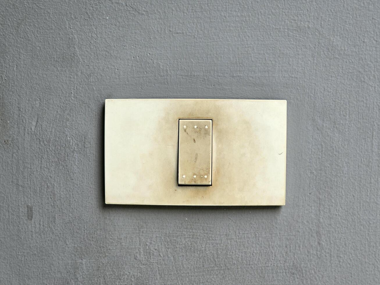 old light switch that has been used for a long time is attached to the wall photo