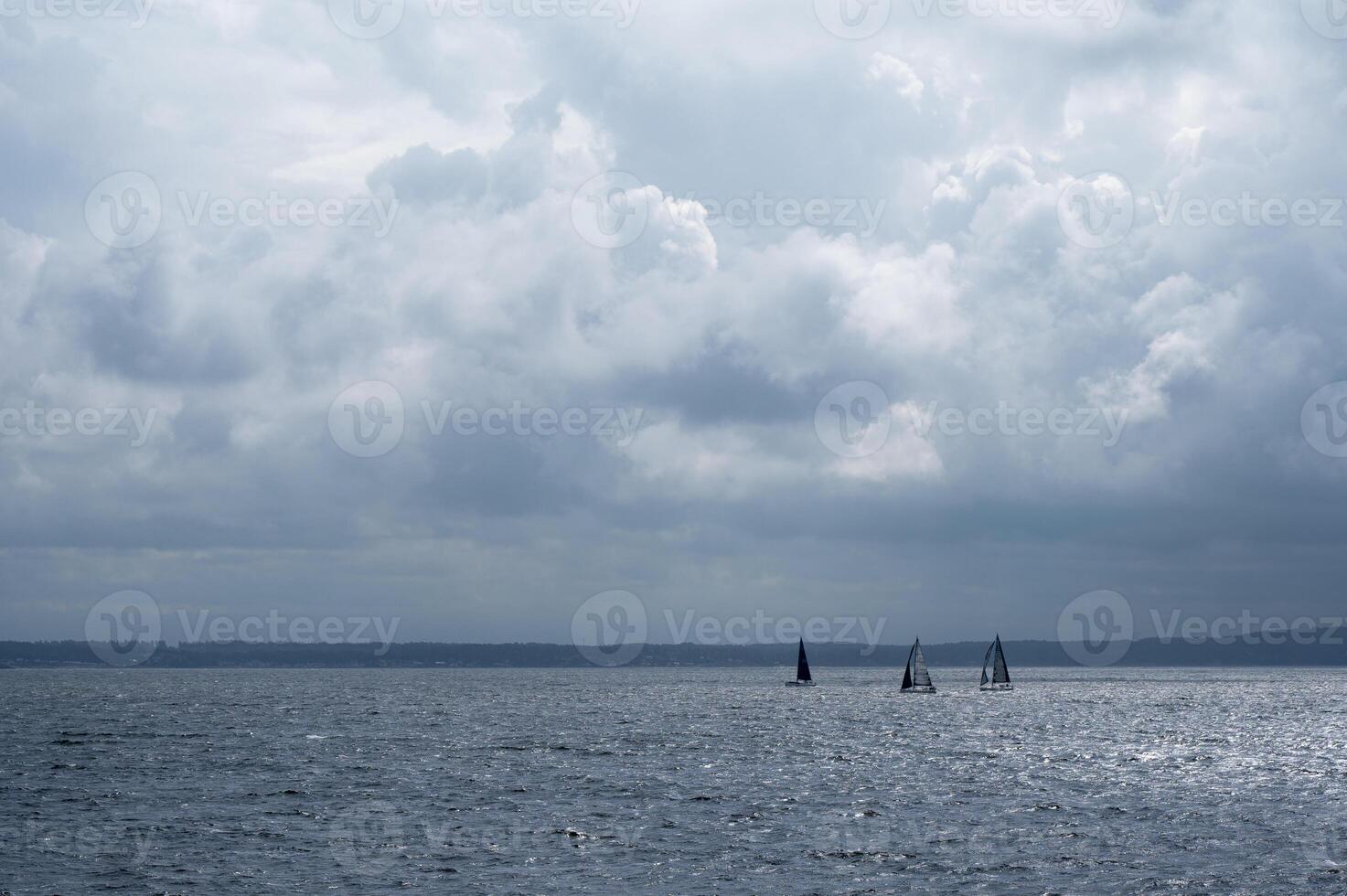 Sailboats on choppy water under a tumultuous sky. photo