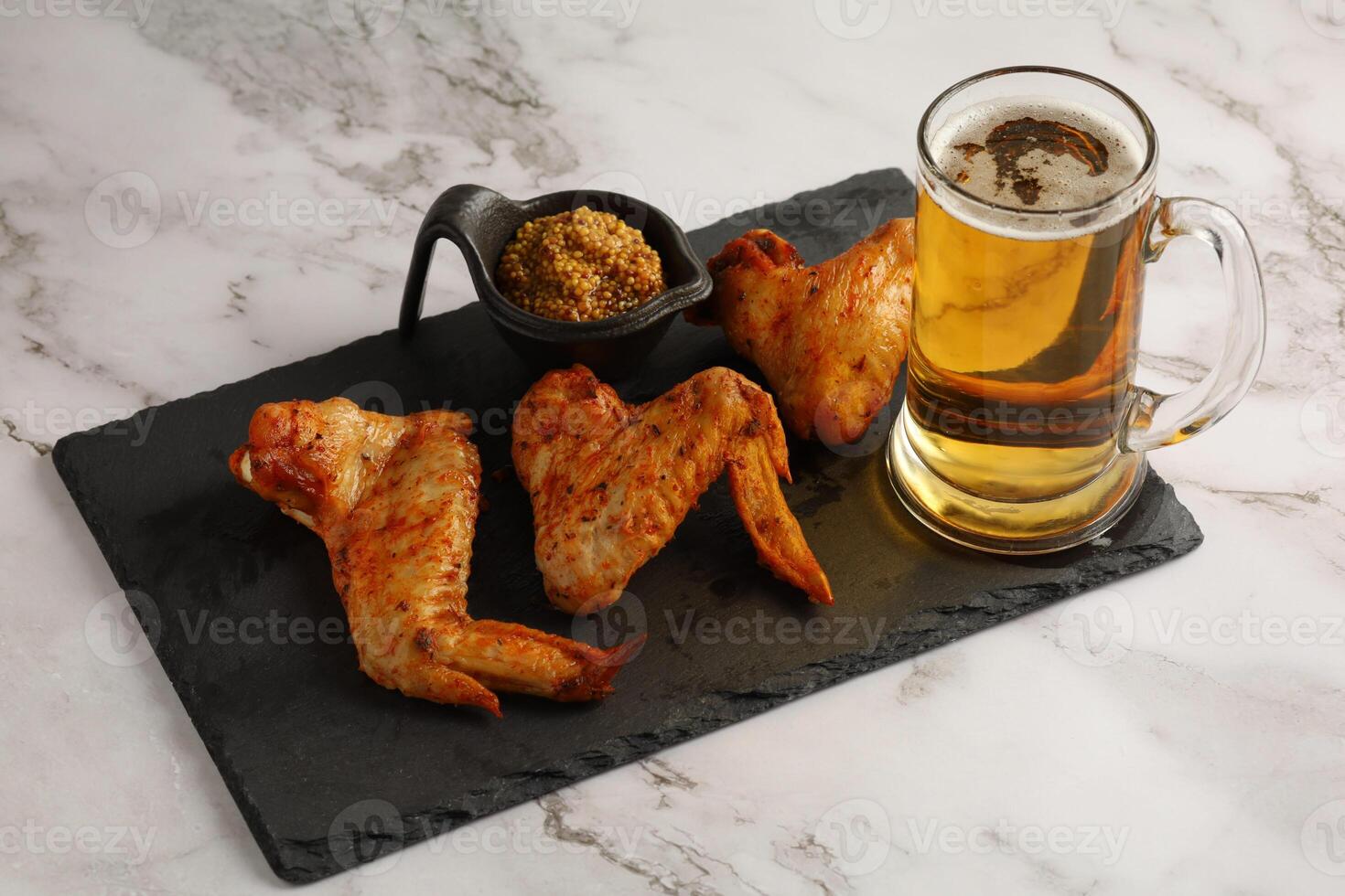 chicken wings and beer. Hearty and tasty food. Plate of delicious barbecue chicken wings photo
