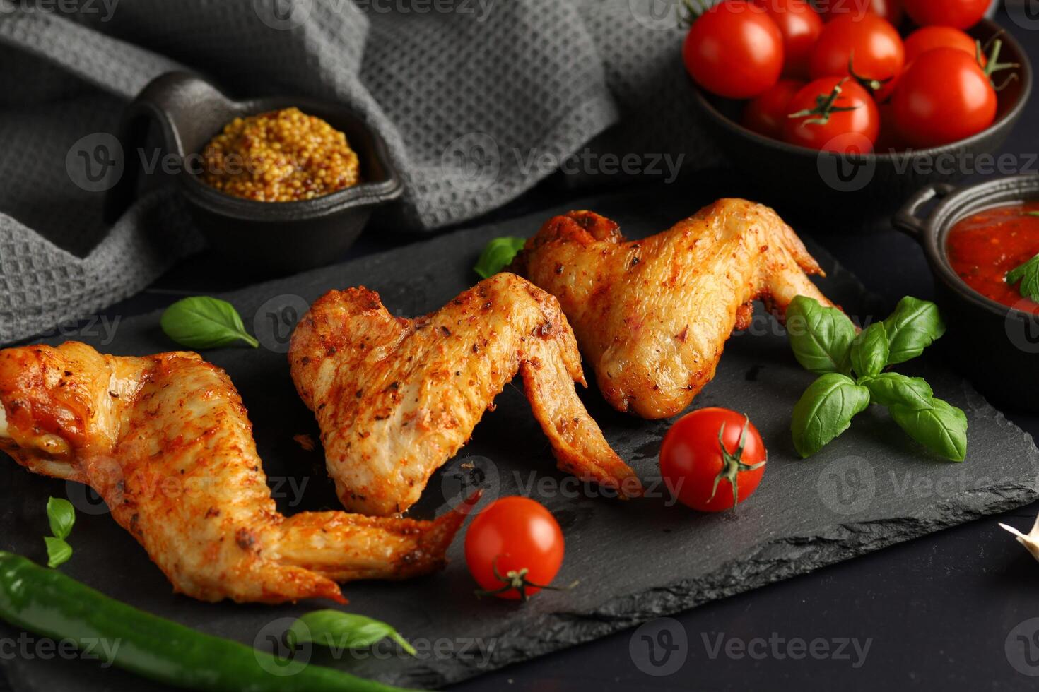 Chicken wings with vegetables and herbs. plate of grilled chicken wings photo