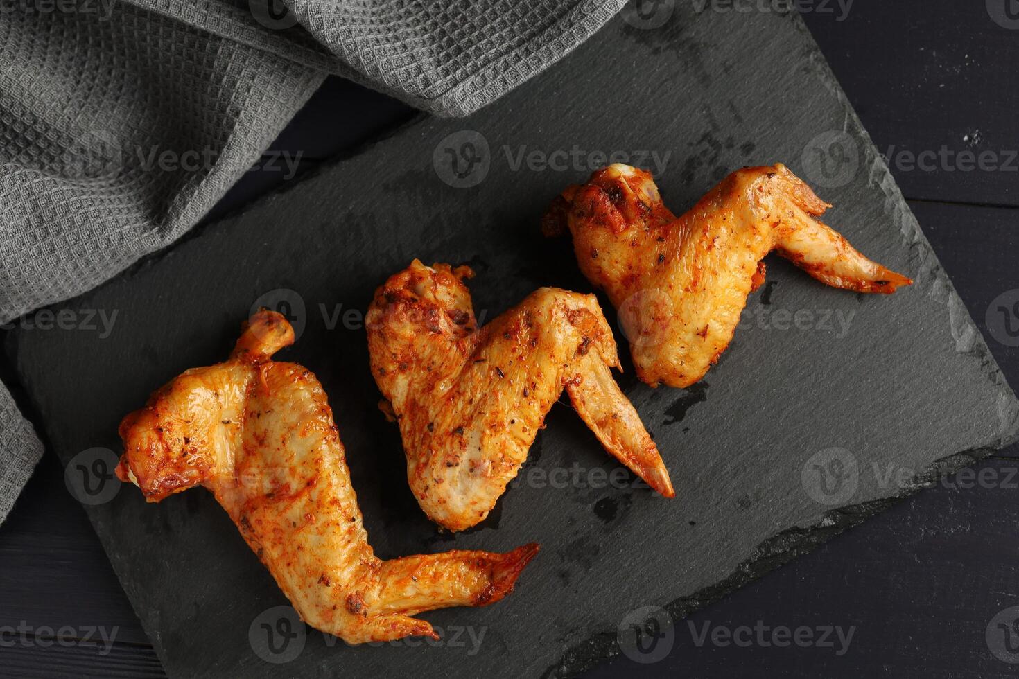 Bbq buffalo wings. Fried chicken on a dark background. delicious grilled chicken wings photo