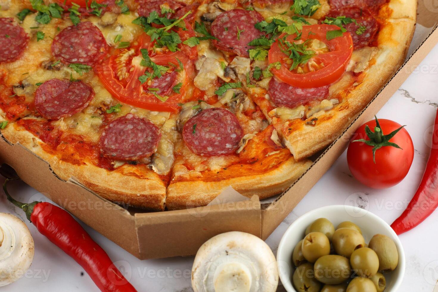 Pizza in a box on the table. Hot pizza with vegetables. Pizza in a restaurant. photo