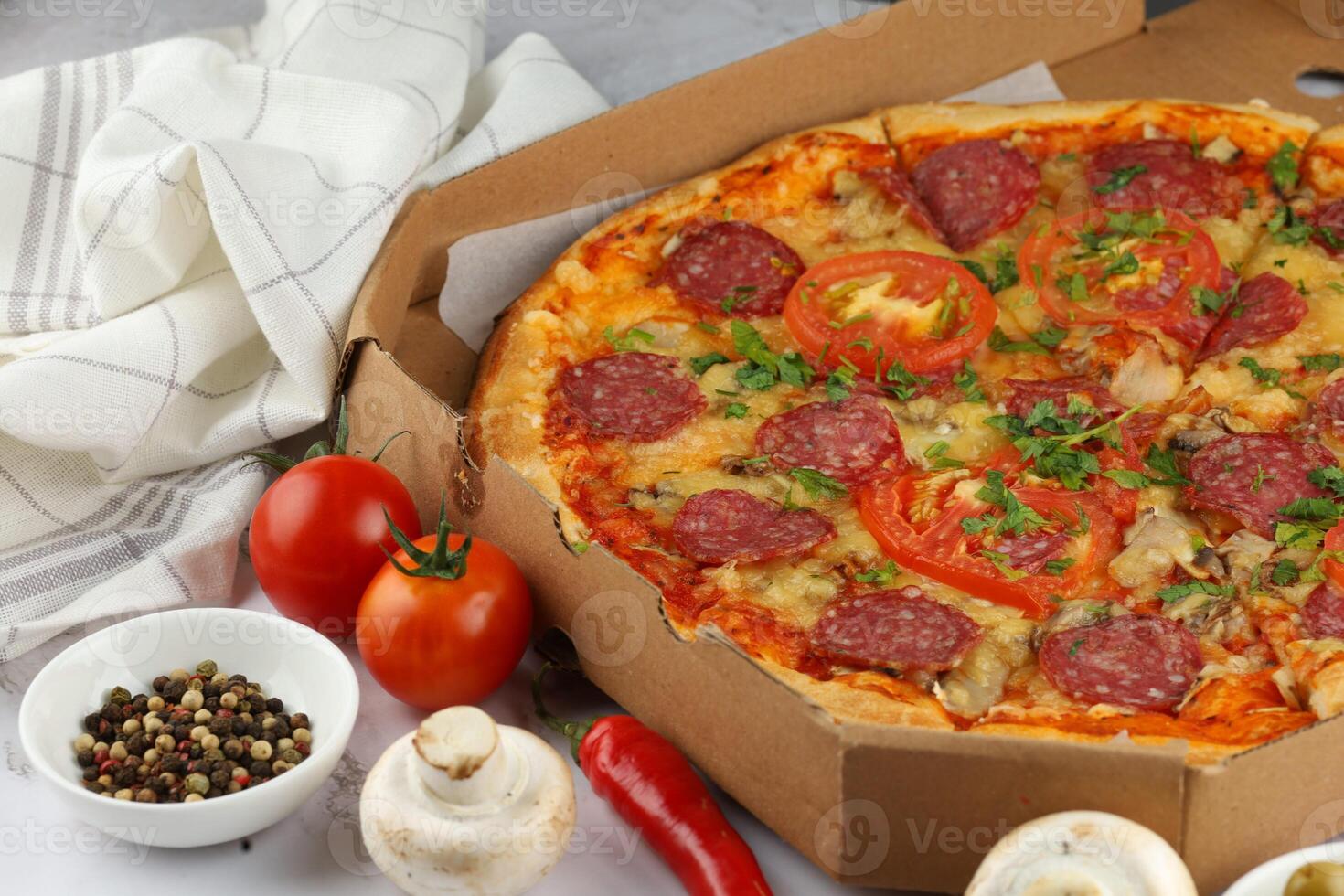Pizza in a box on the table. Hot pizza with vegetables. Pizza in a restaurant. photo