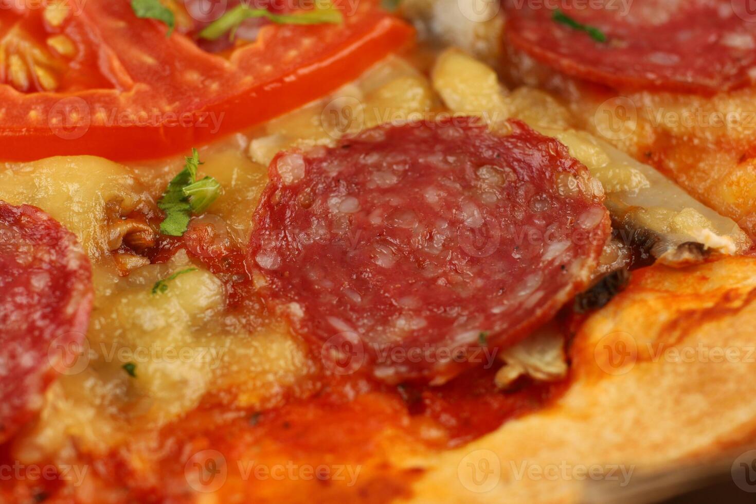 Pizza with sausage, tomatoes and cheese close-up. Hot tasty traditional italian pizza photo