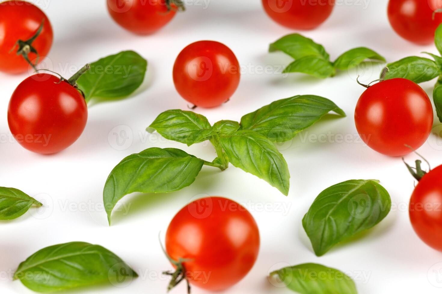 basil and tomato cherry. Ripe red cherry tomatos and basil on white background photo