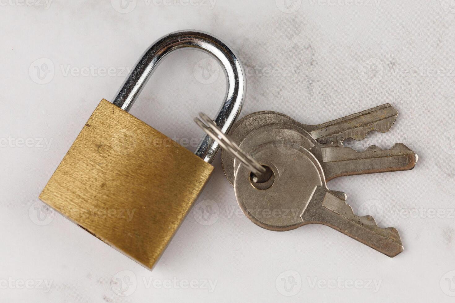 Small lock with keys. Locked Golden Padlock on the white background photo