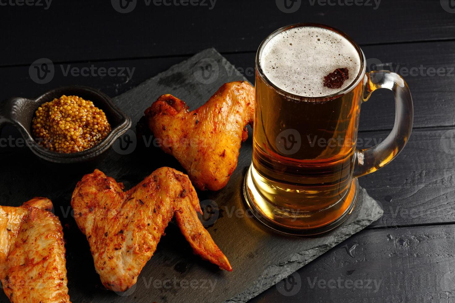 chicken wings and beer. Hearty and tasty food. Plate of delicious barbecue chicken wings photo