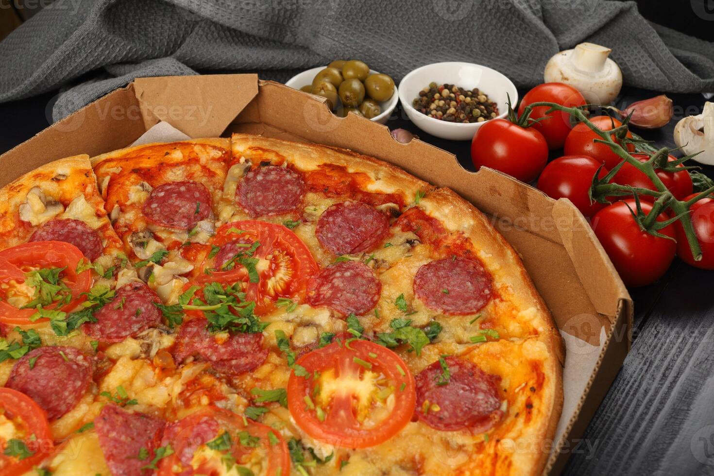 Pizza in a box on the table. Hot pizza with vegetables. Pizza in a restaurant. photo