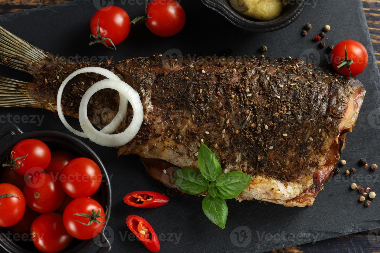 Fried carp fish with vegetables, tomatoes and lemon. Grilled carp with vegetables photo