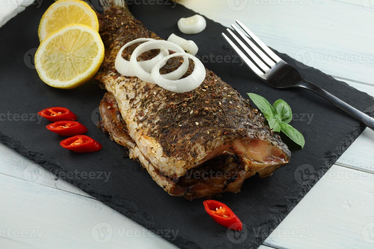 Baked fish on the table. Baked carp. fish for dinner photo