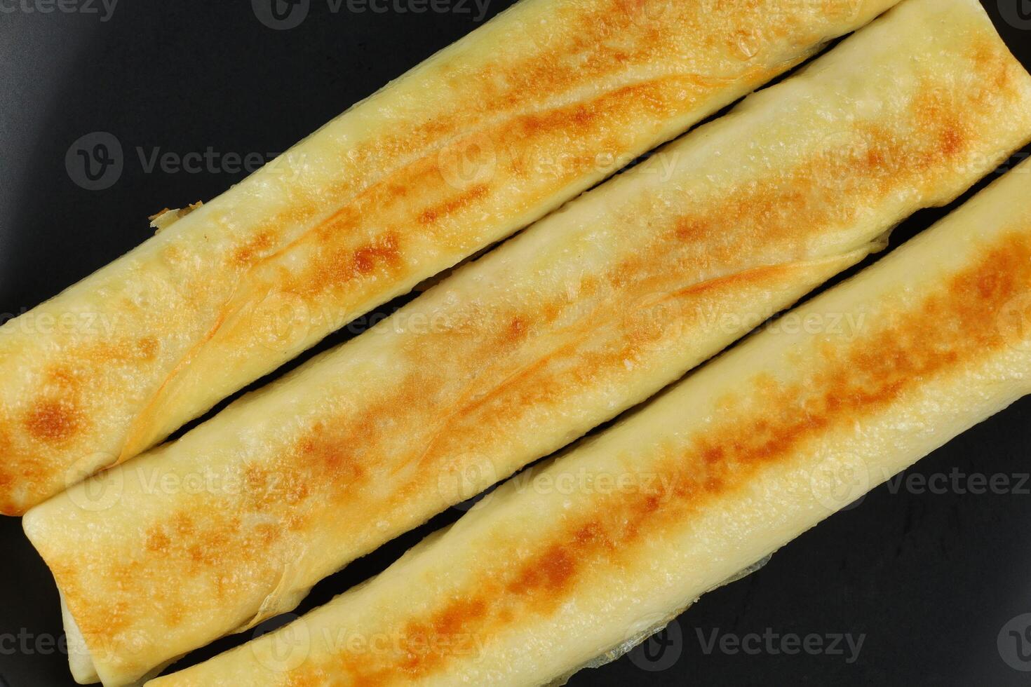 Pancakes rolls on a black plate. photo