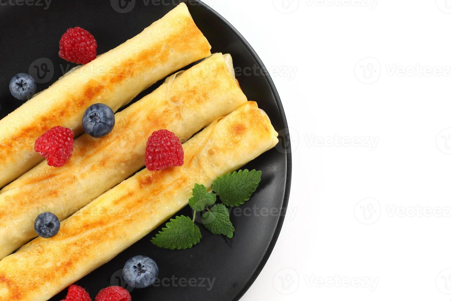 panqueques rollos con frambuesas y arándanos aislar foto