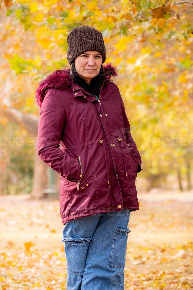 Latin woman poses for the camera in an autumn landscape. She is middle aged and looks very natural. photo