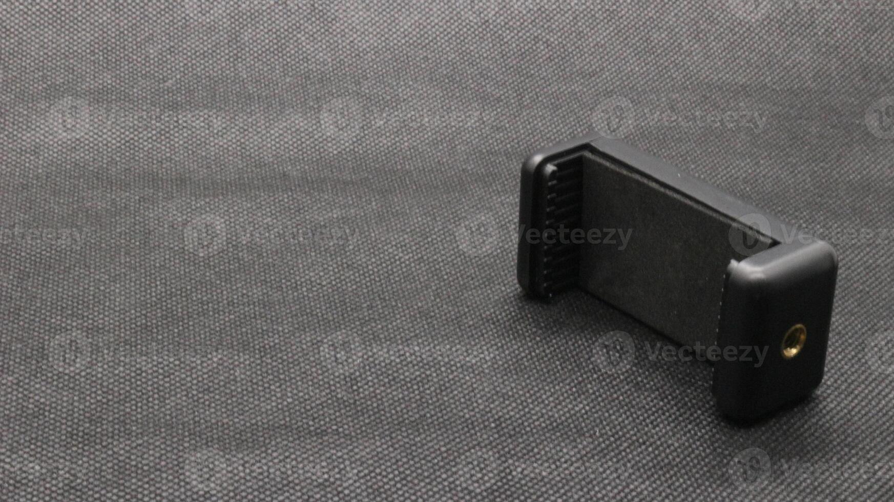 Tripod U holder for smart phone and camera isolated photo