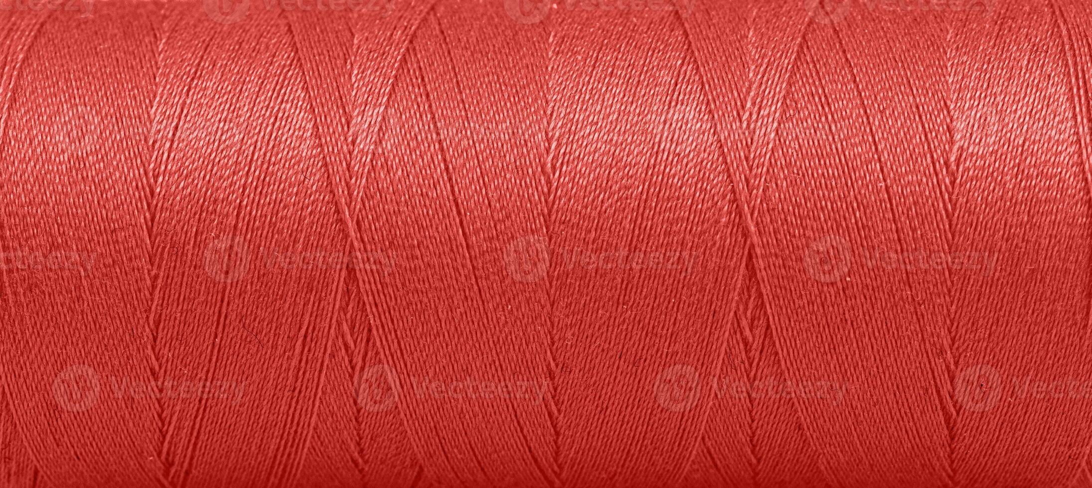 Texture of threads in a spool of red color on a white background photo