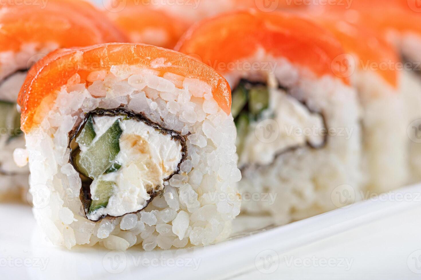 Sushi with salmon on a white plate with wasabi, ginger, soy, chopsticks on a white background photo
