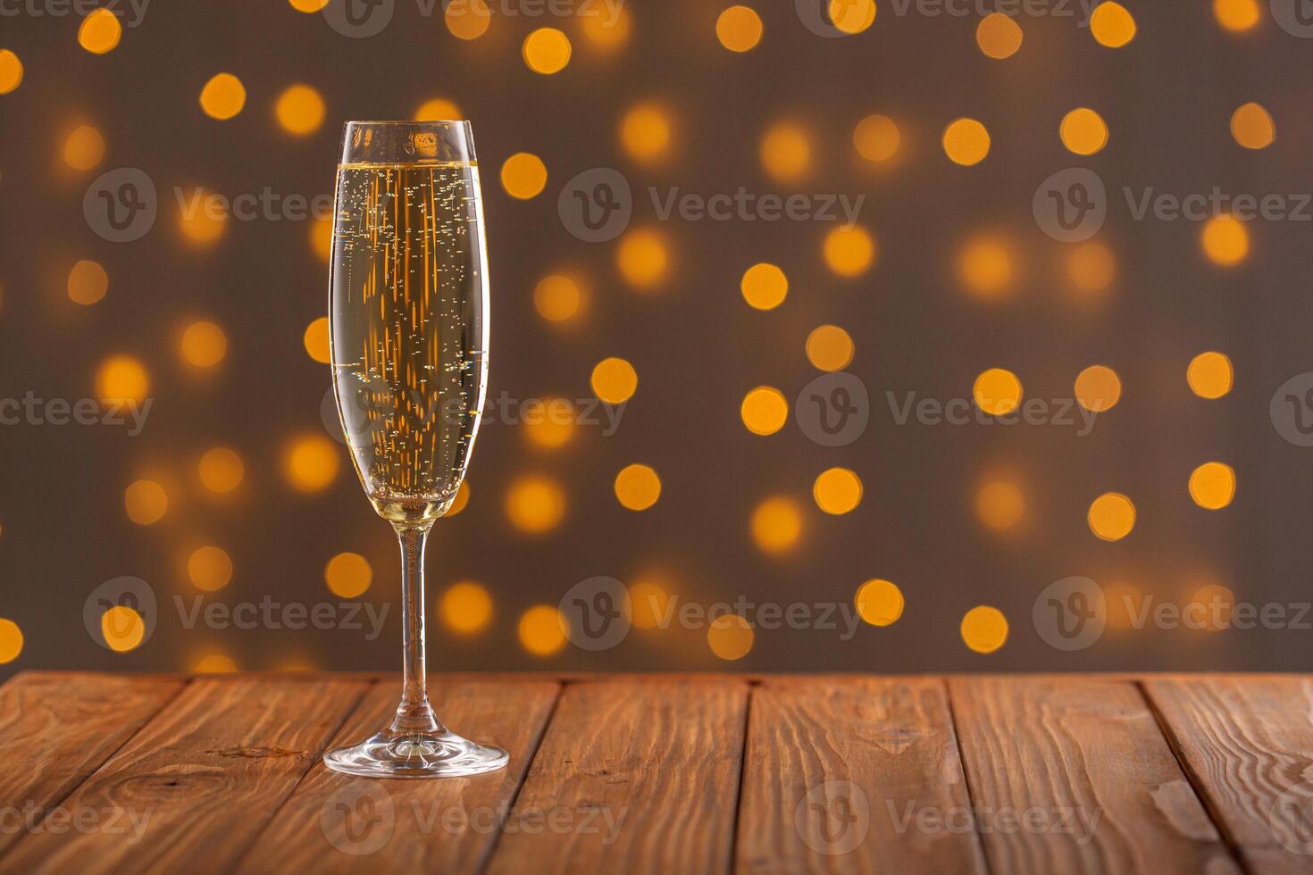 Glasses with champagne on a wooden background against a bokeh background of lights photo