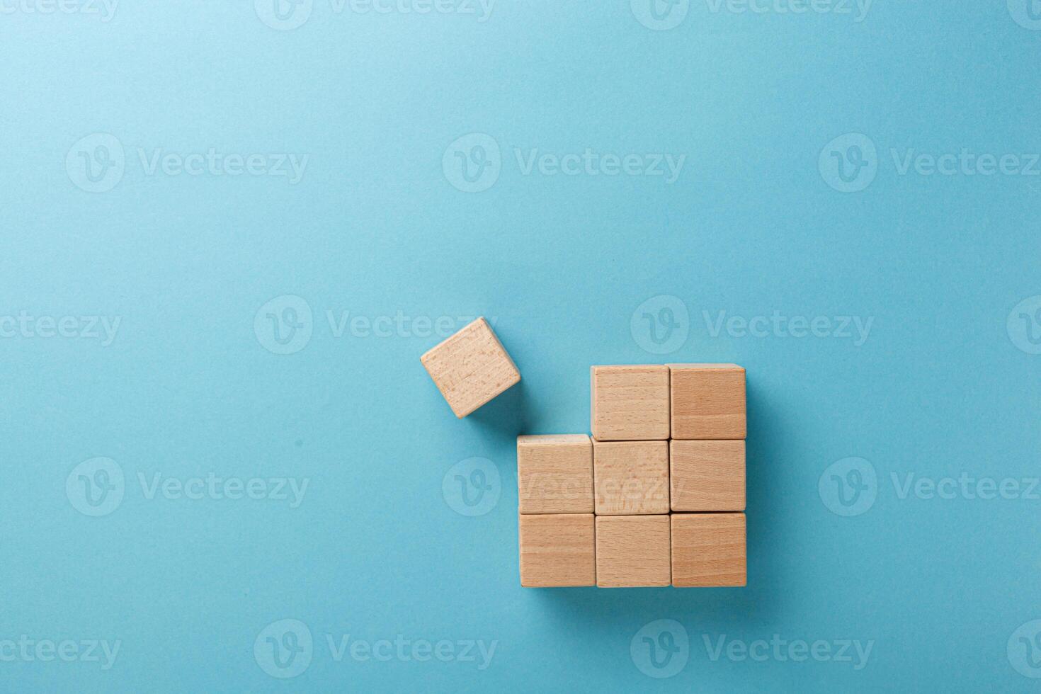 wooden cubes in a square of nine pieces in a row on a blue background photo