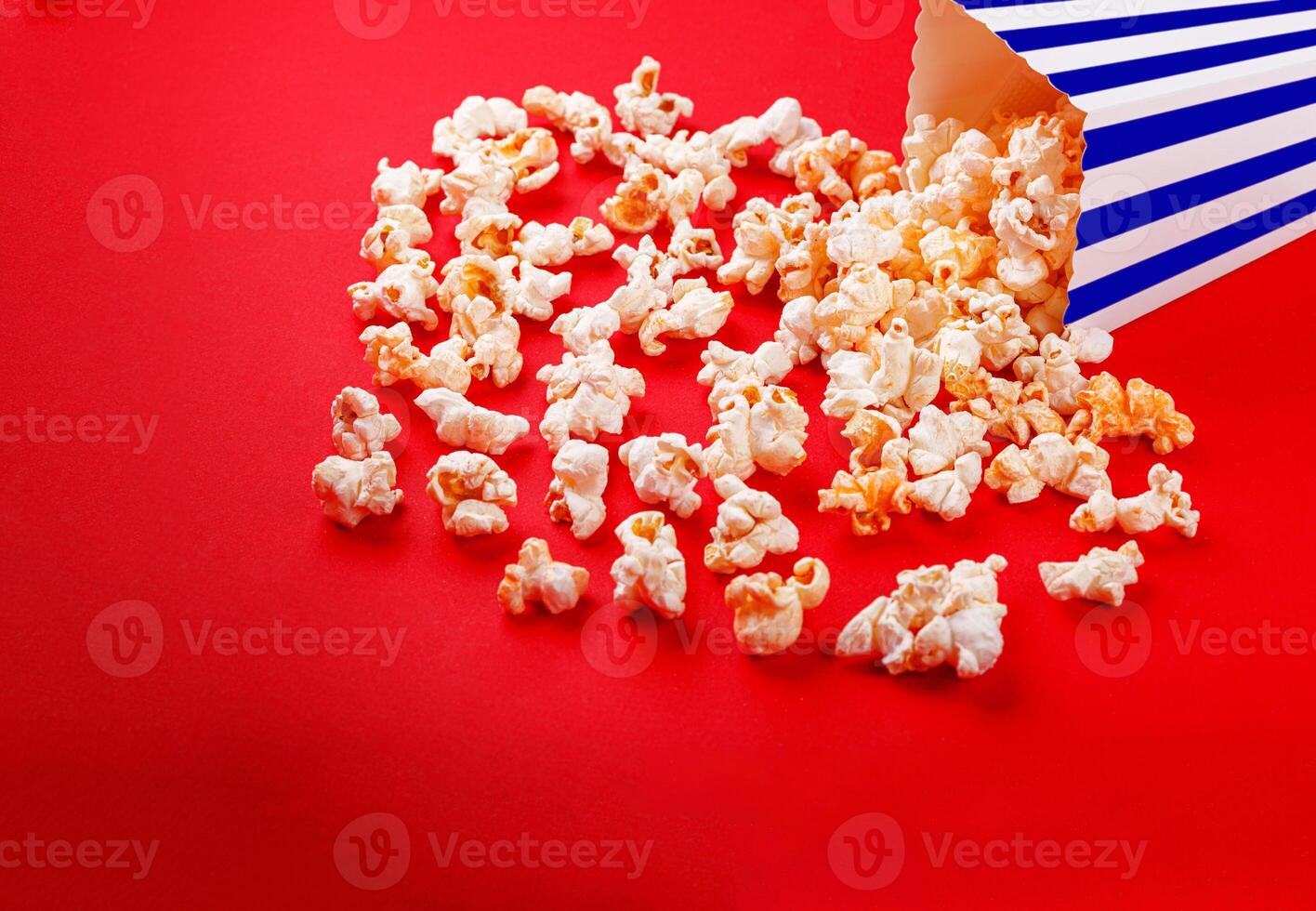 cardboard box with popcorn on a red background photo