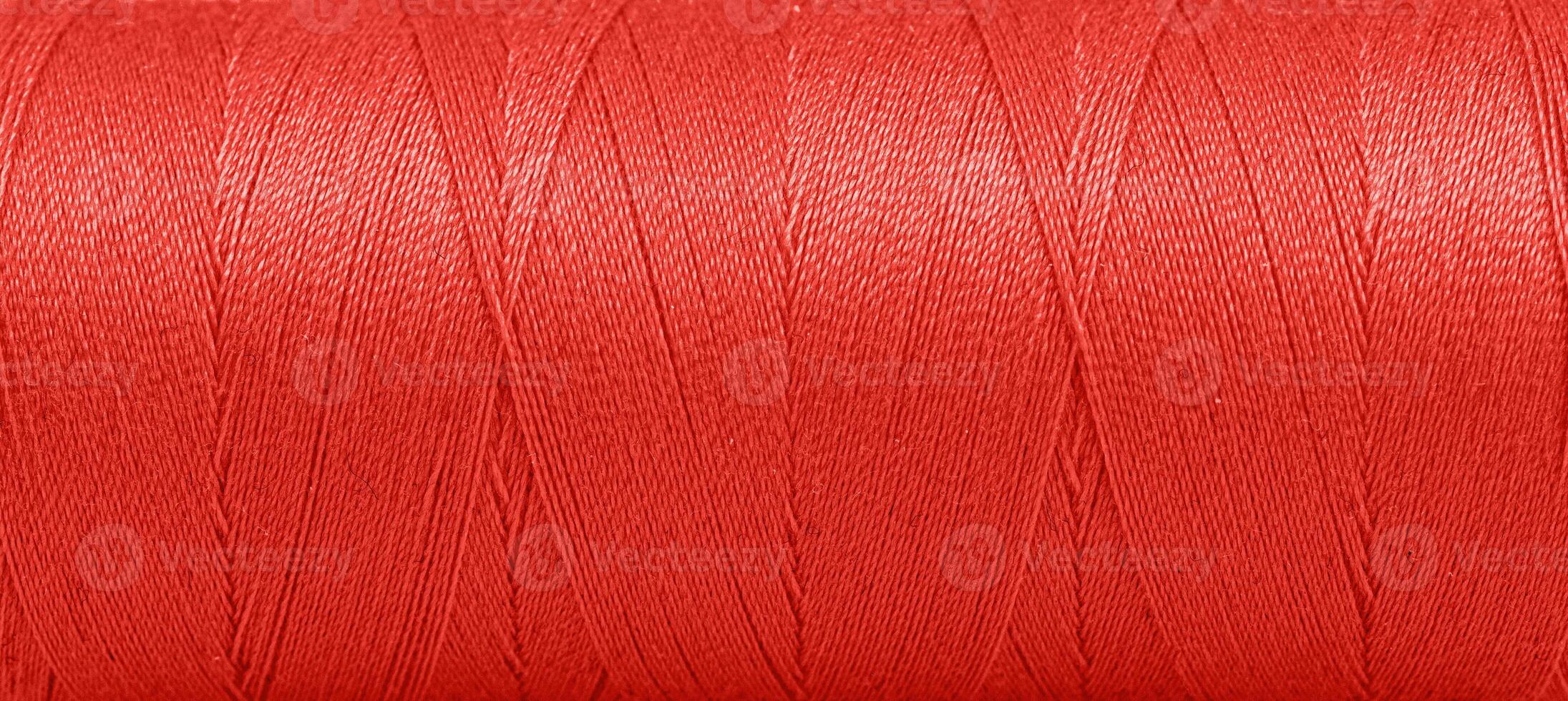 Texture of threads in a spool of red color on a white background photo