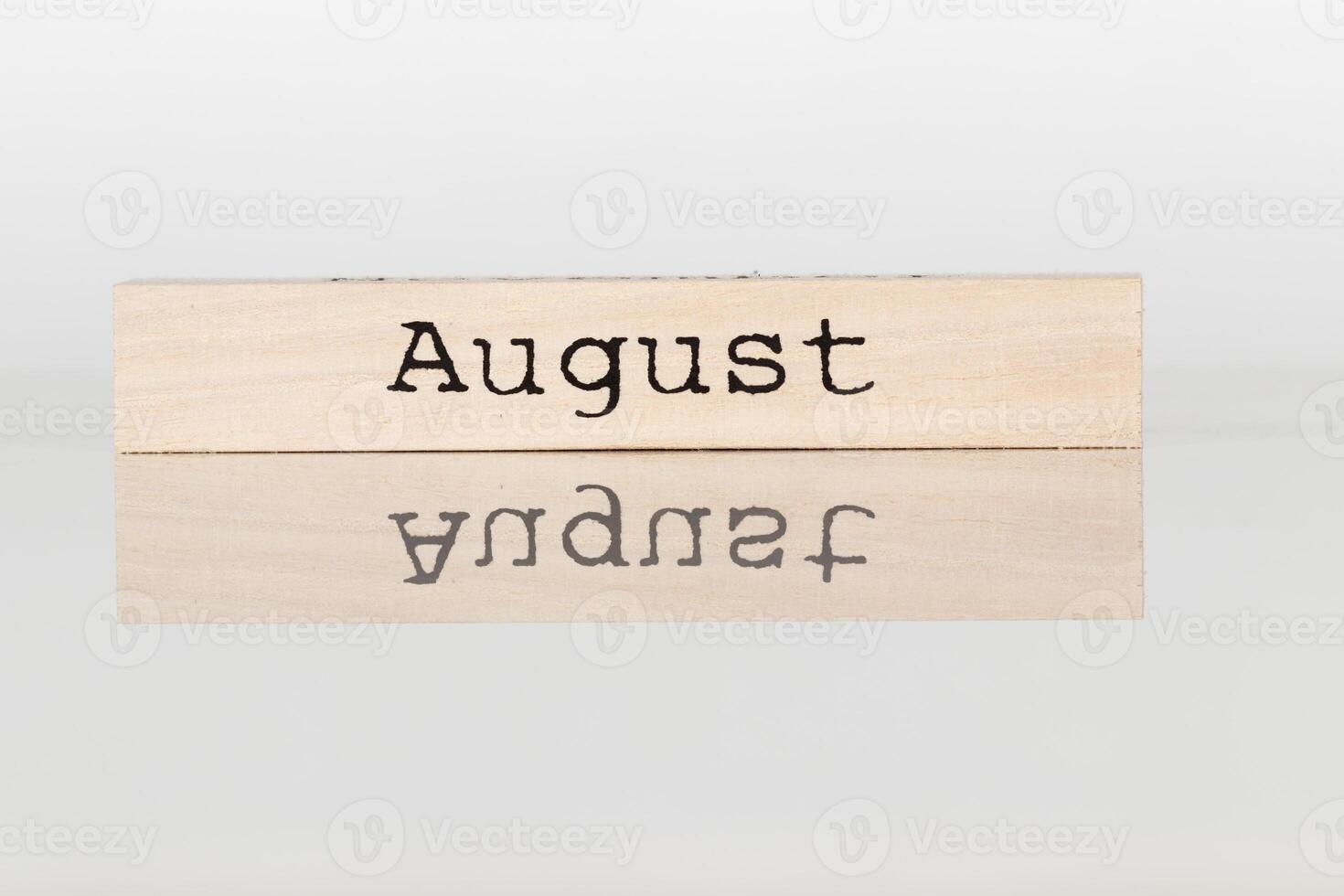 a wooden cube with the inscription August on a white background photo