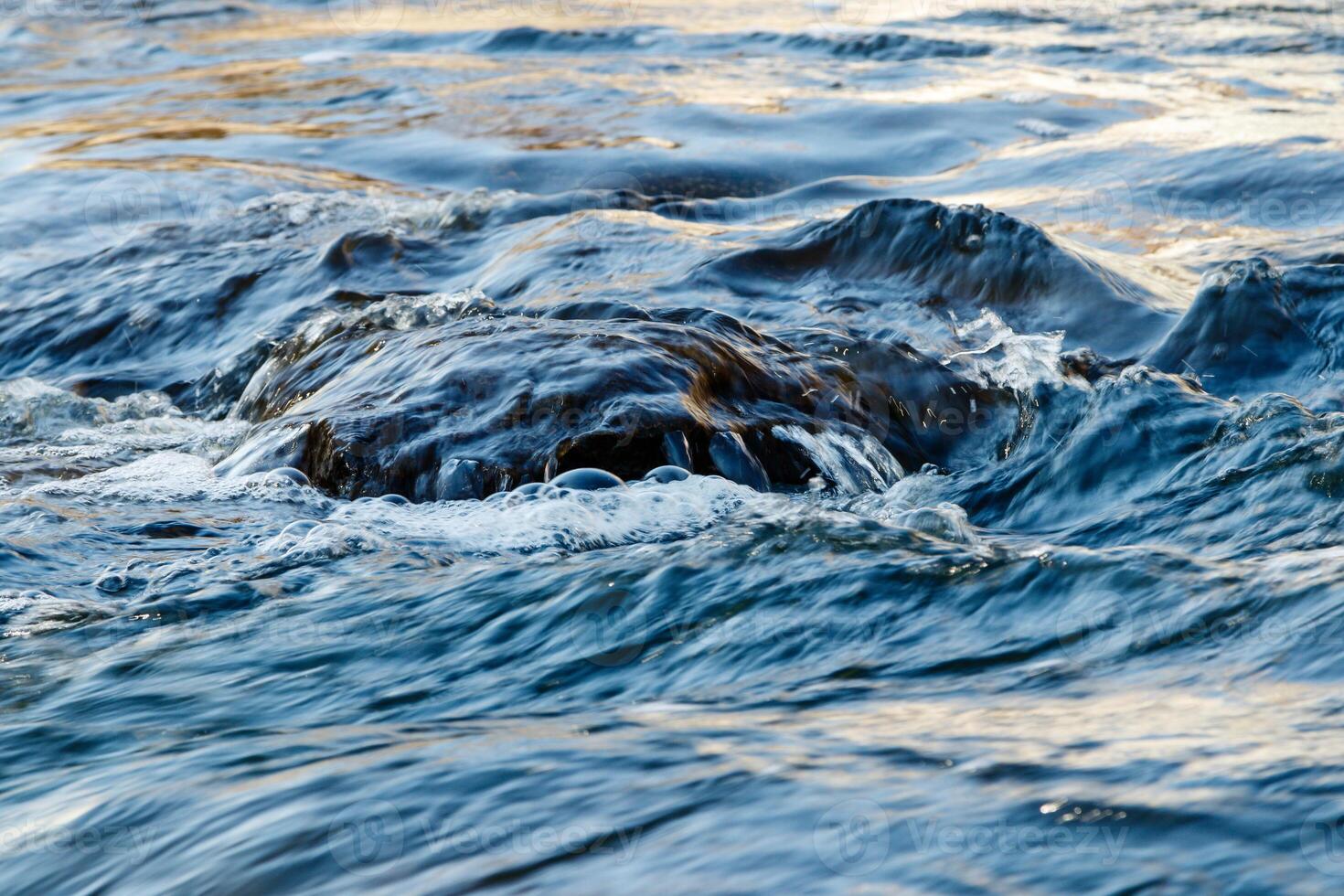 flow of water and spray from a stone photo