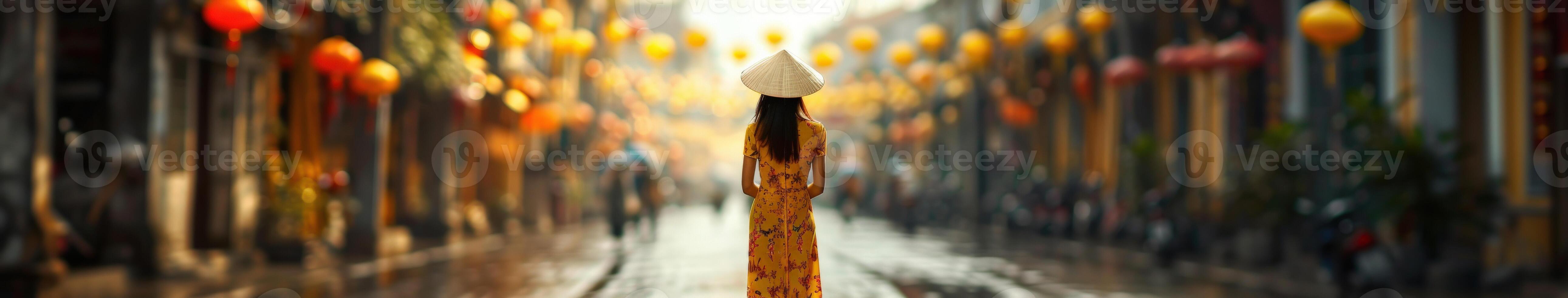Vietnamese Woman In Traditional Dress Walking Through Hoi An photo