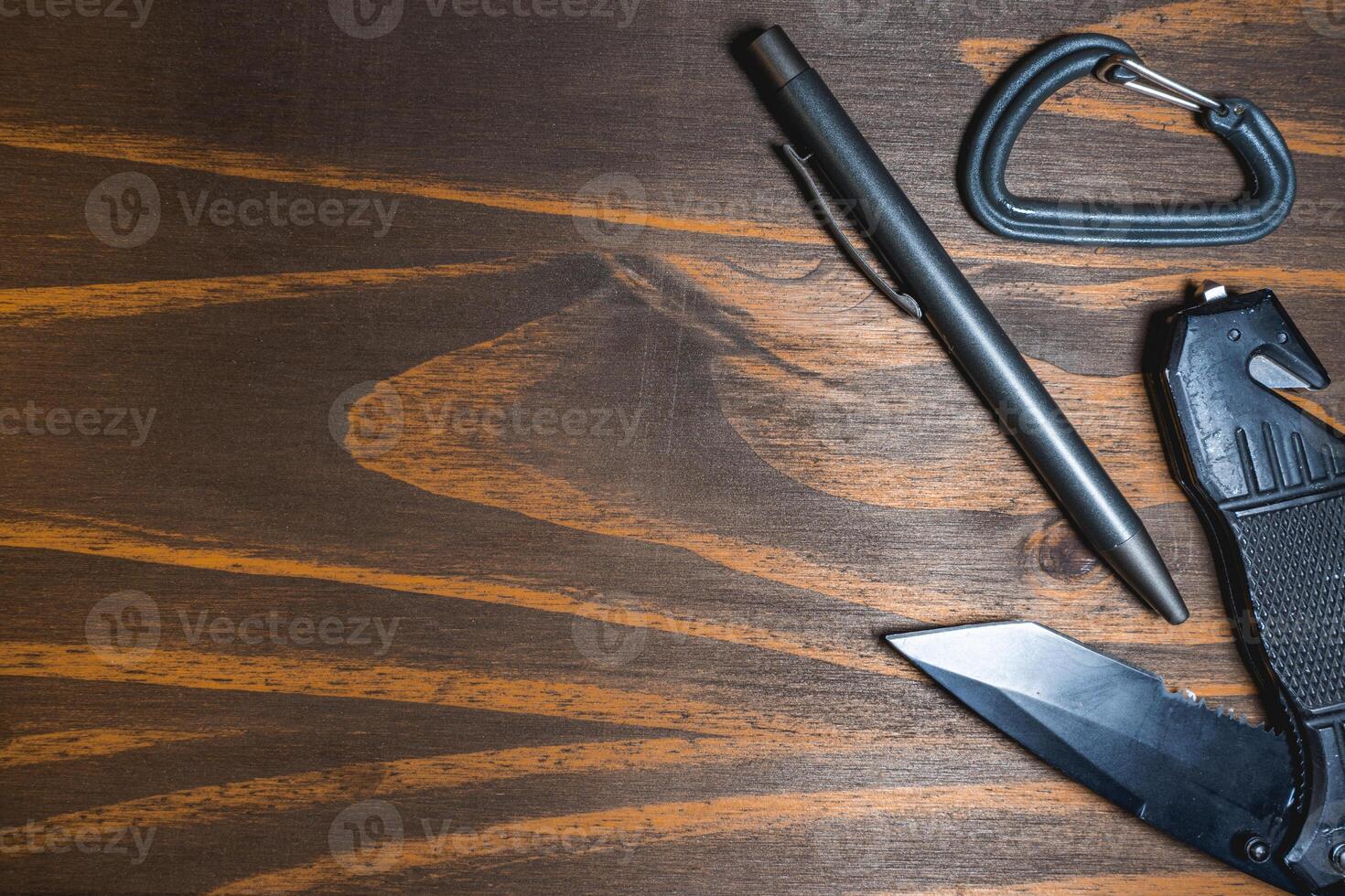 Flatlay background of some EDC gear, Knife, Carabiner and a pen. photo