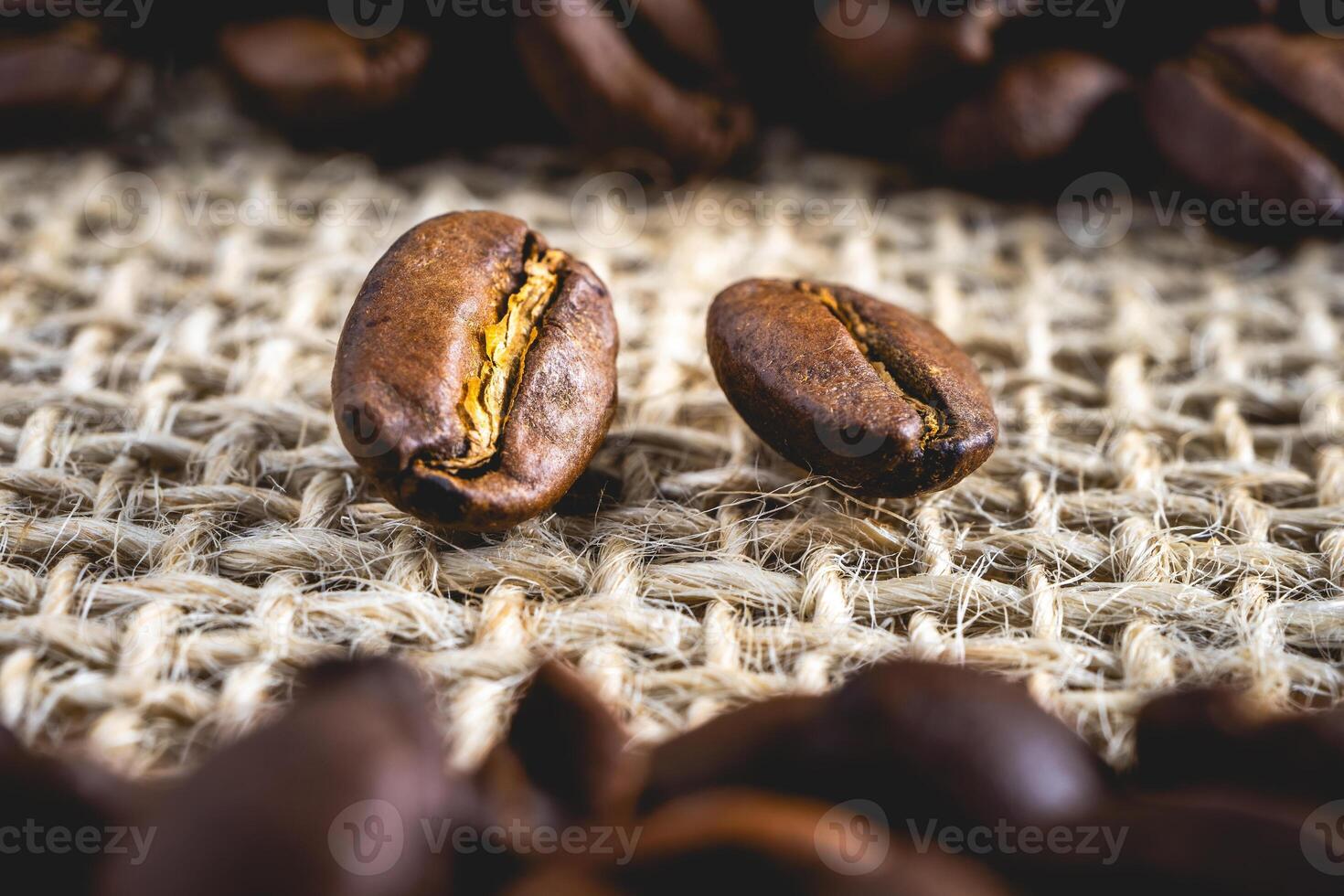 Close up from a few coffee beans laying down on a Burlap fabric background. Background voor coffee related products. photo