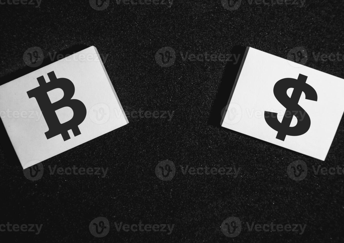 Two sticky notes on a black background with a bitcoin and a dollar on it. photo