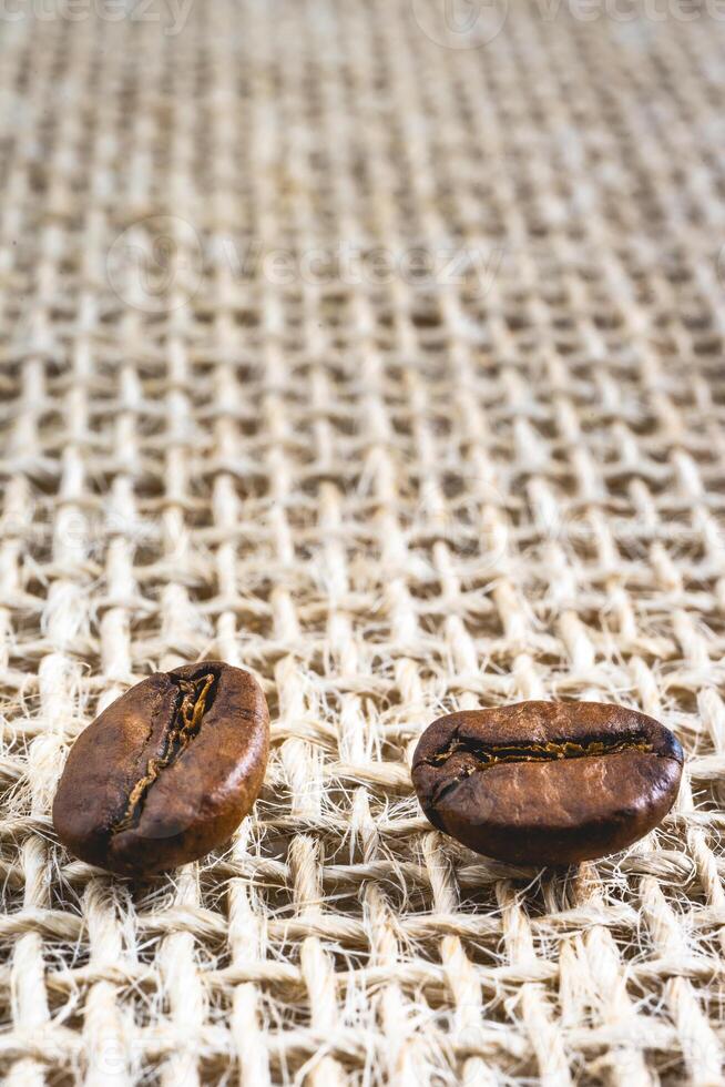Close up from a few coffee beans laying down on a Burlap fabric background. Background voor coffee related products. photo