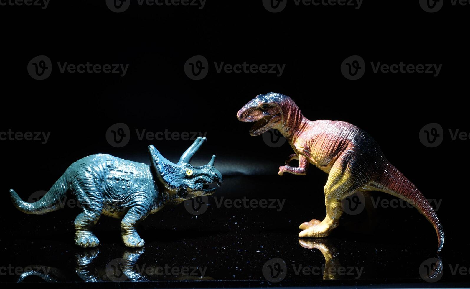 two dinosaurs, a tyrannosaurus rex and a triceratops fight in a realistic prehistoric setting illuminated by the moon photo