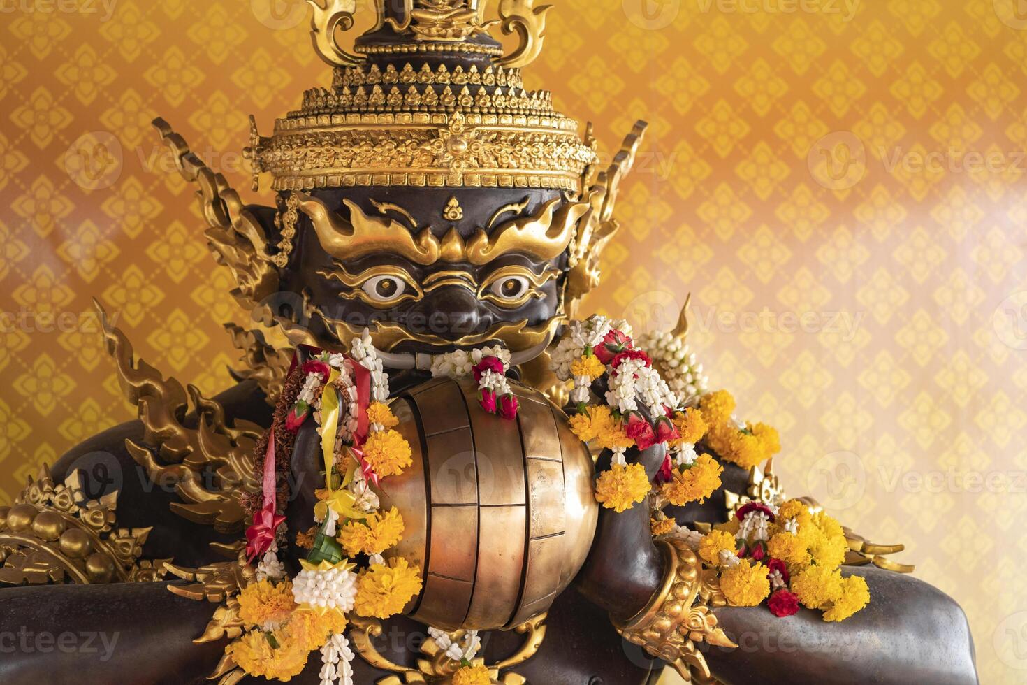 Rahu, the demon who causes eclipses, In Thailand, it is believed that this demon eats the moon, causing a lunar eclipse. He is eating spheres and with flowers in his hand. photo