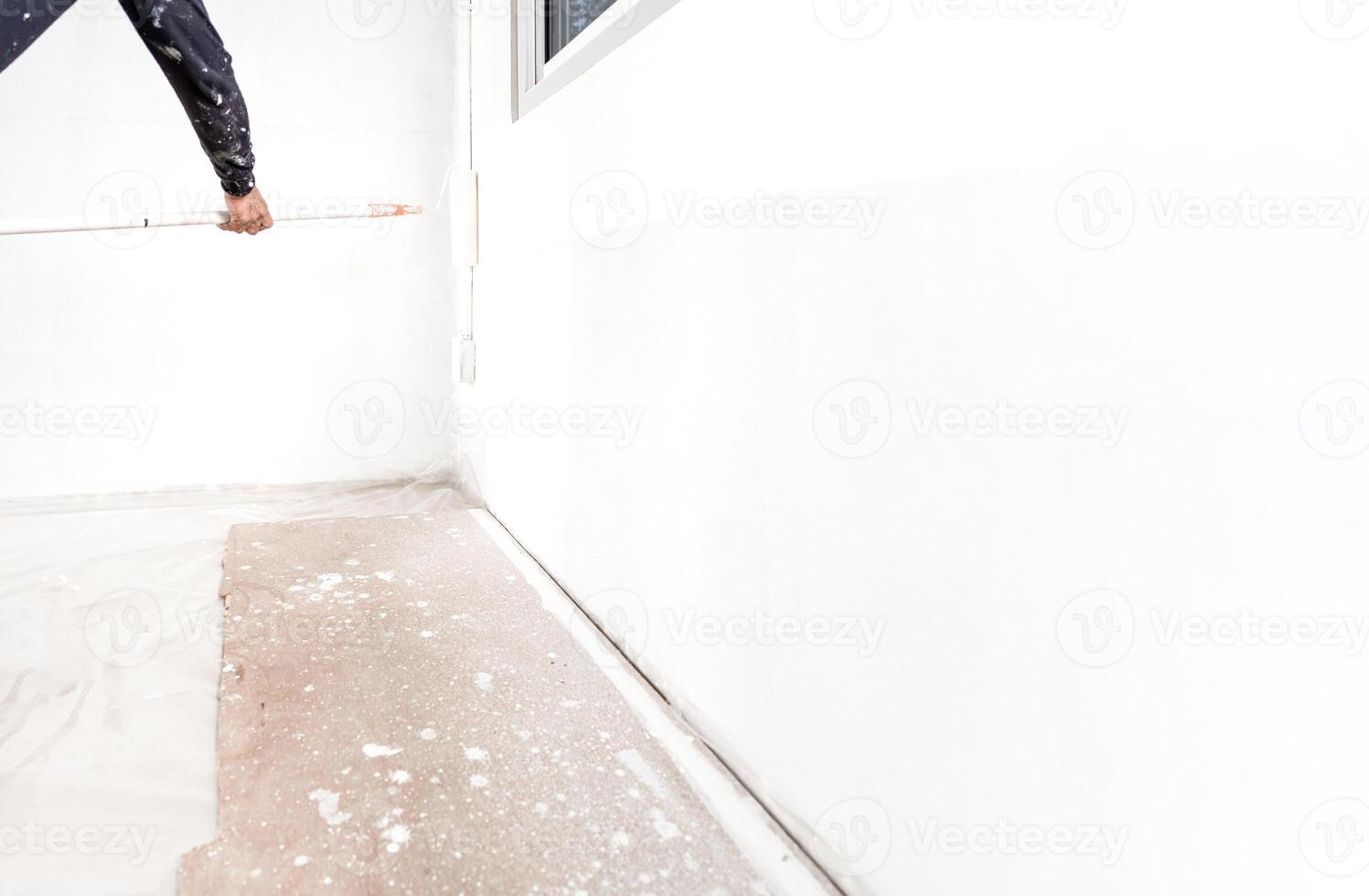 professional worker man is rolling and painting interior white wall. photo