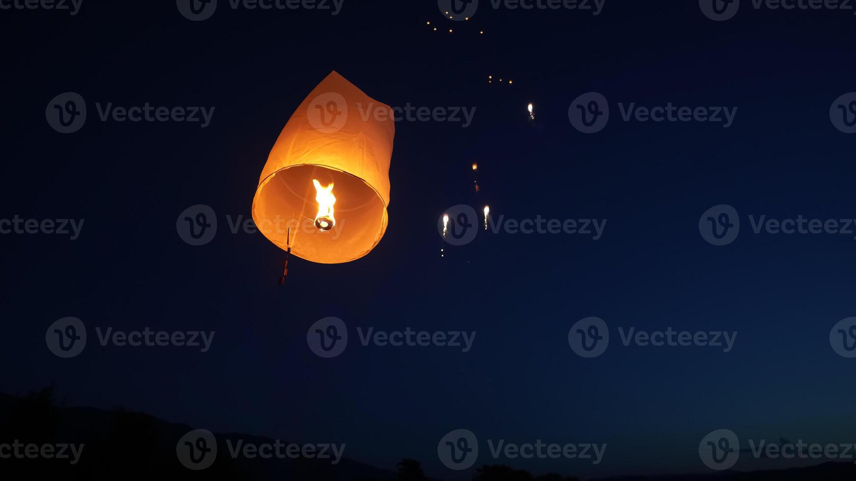 Release the traditional paper lanterns into the sky during the night of the festival in Thailand. photo