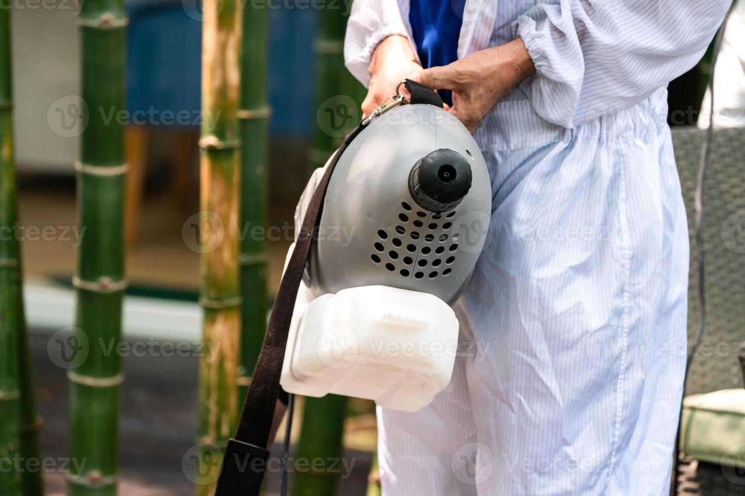 Professional technical man in prevention suit with his sterilizing machine and disinfecting water sprays in toilet or wc area field for purifying coronavirus COVID-19 photo