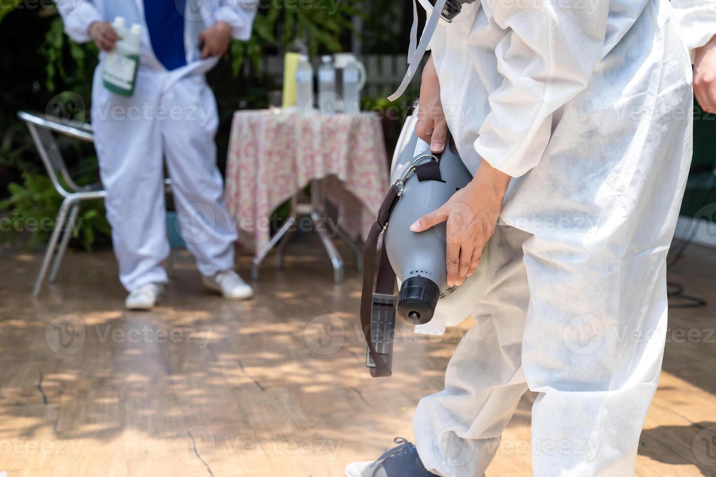 Professional technical man in prevention suit with his sterilizing machine and disinfecting water sprays in toilet or wc area field for purifying coronavirus COVID-19 photo