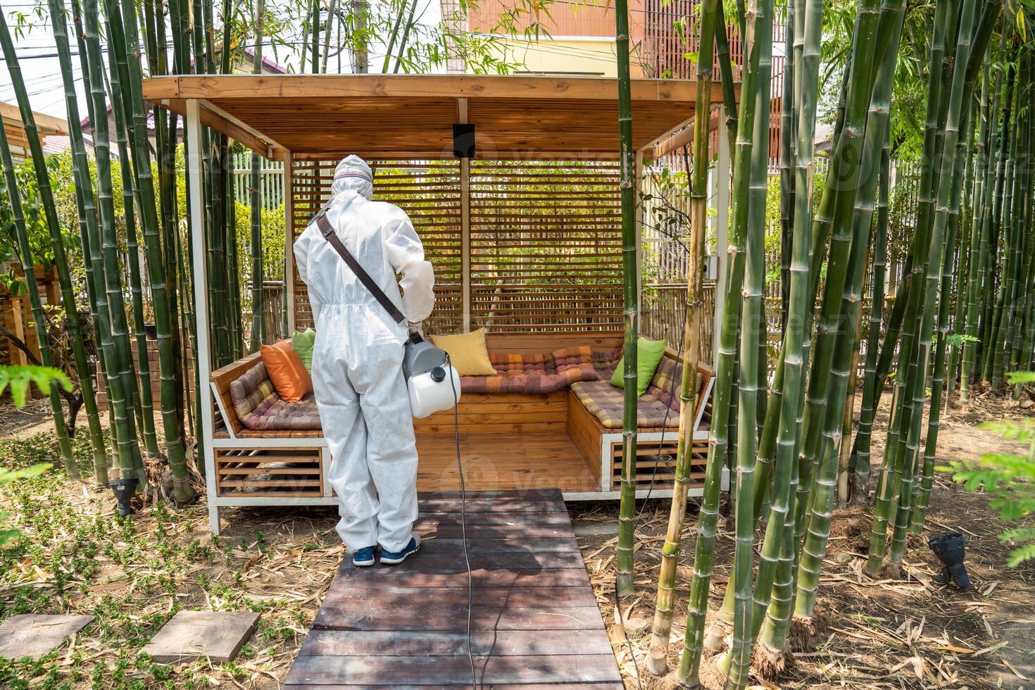 Professional technical man in prevention suit with his sterilizing machine and disinfecting water sprays in toilet or wc area field for purifying coronavirus COVID-19 photo