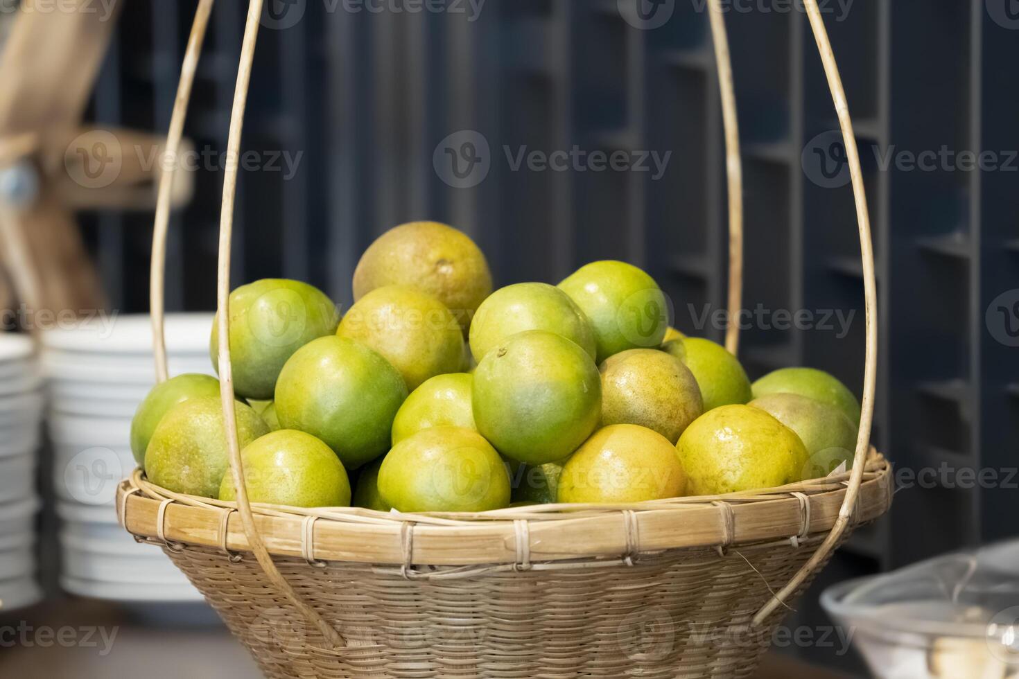 A bunch of oranges in a basket, based on the picture showed that it could be a party or a buffet somewhere else. photo