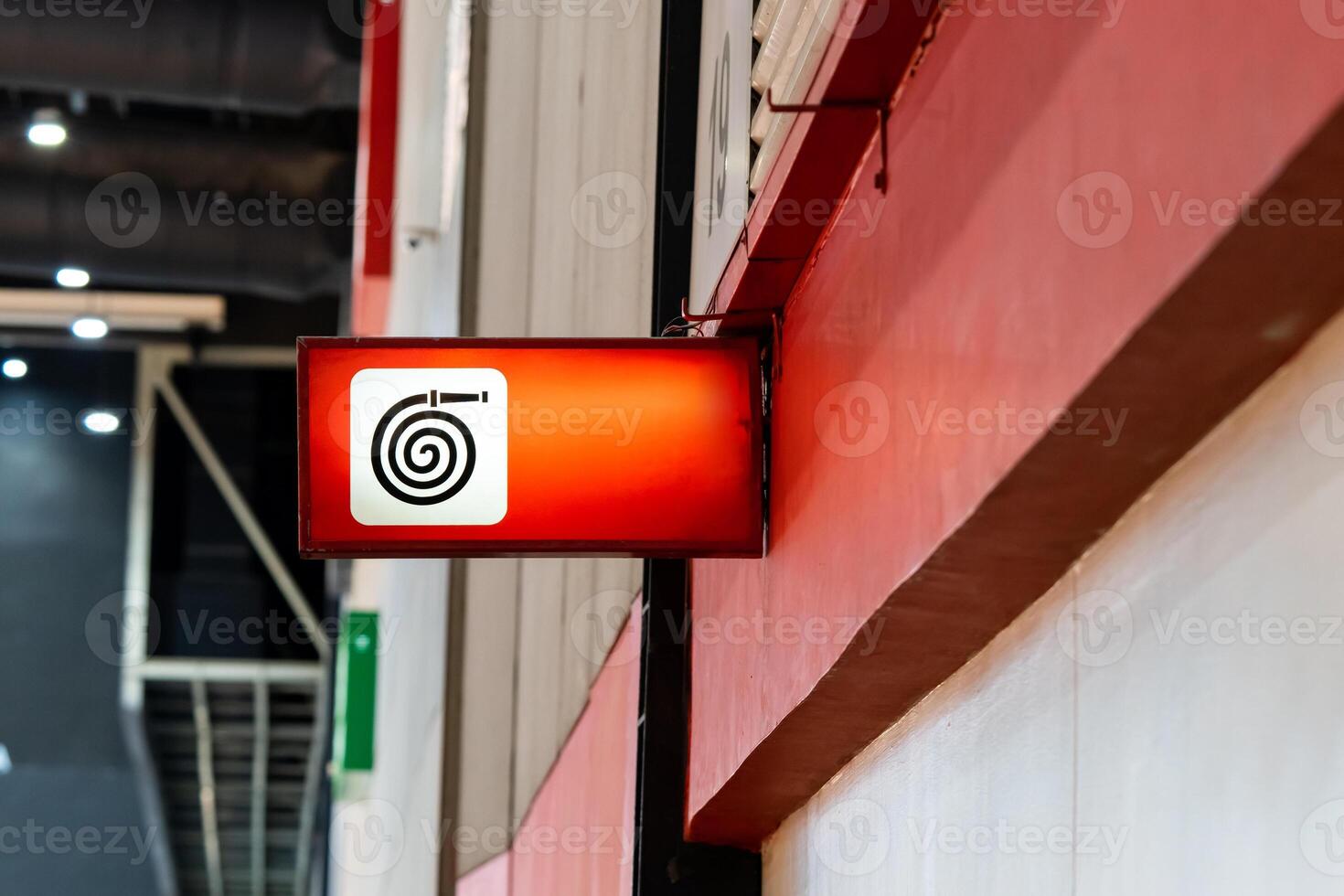 A fire equipment sign installed on a wall. Red light on to be noticeable in an exhibition hall that contains many participants. photo