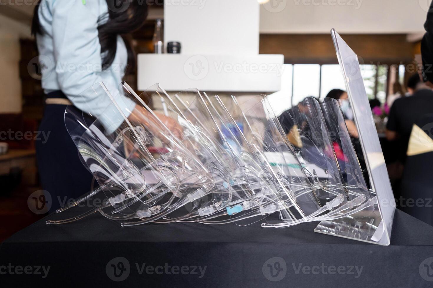 Several face shields were stacked on top of the black table, allocated to protect the staff from germs photo