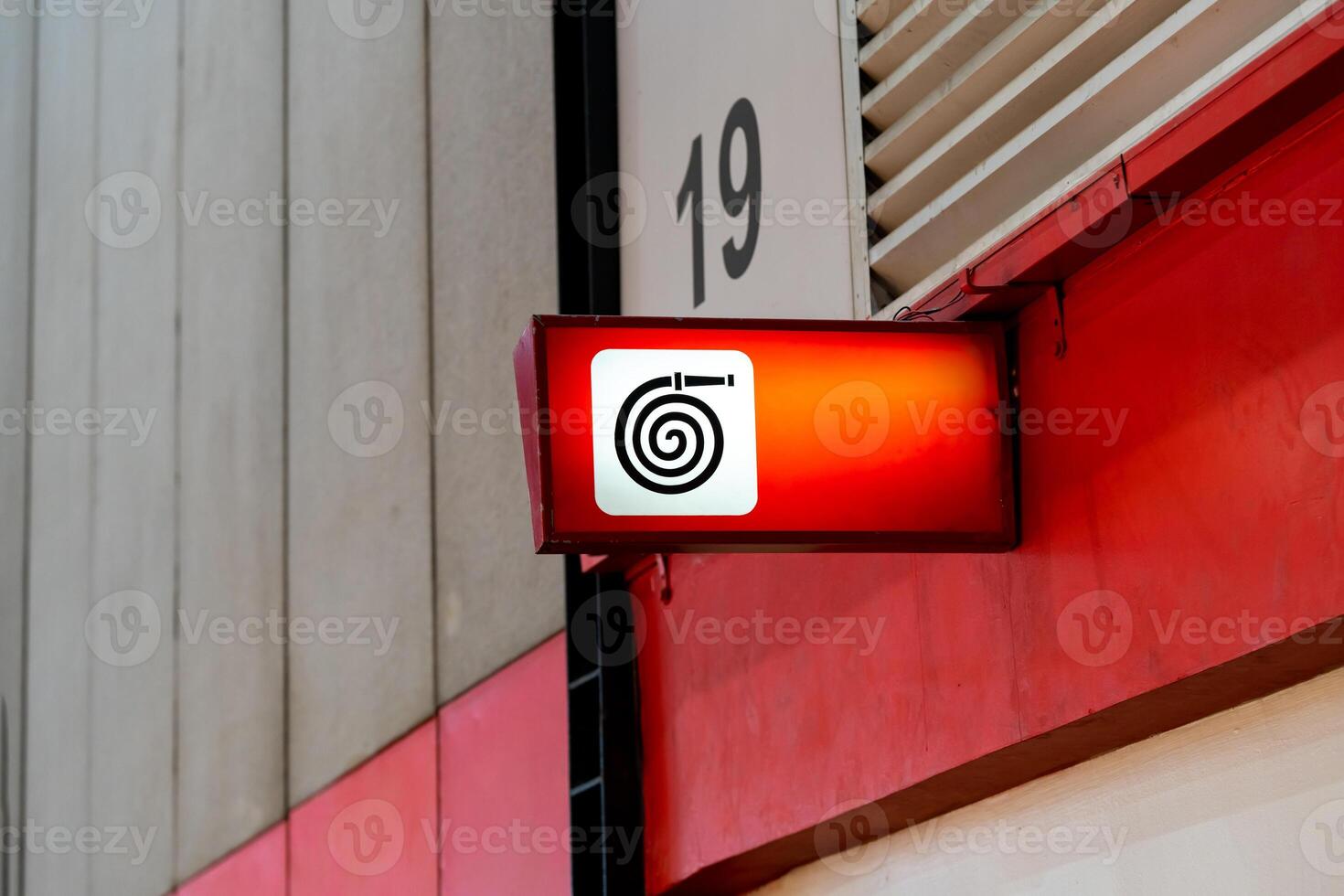A fire equipment sign installed on a wall. Red light on to be noticeable in an exhibition hall that contains many participants. photo