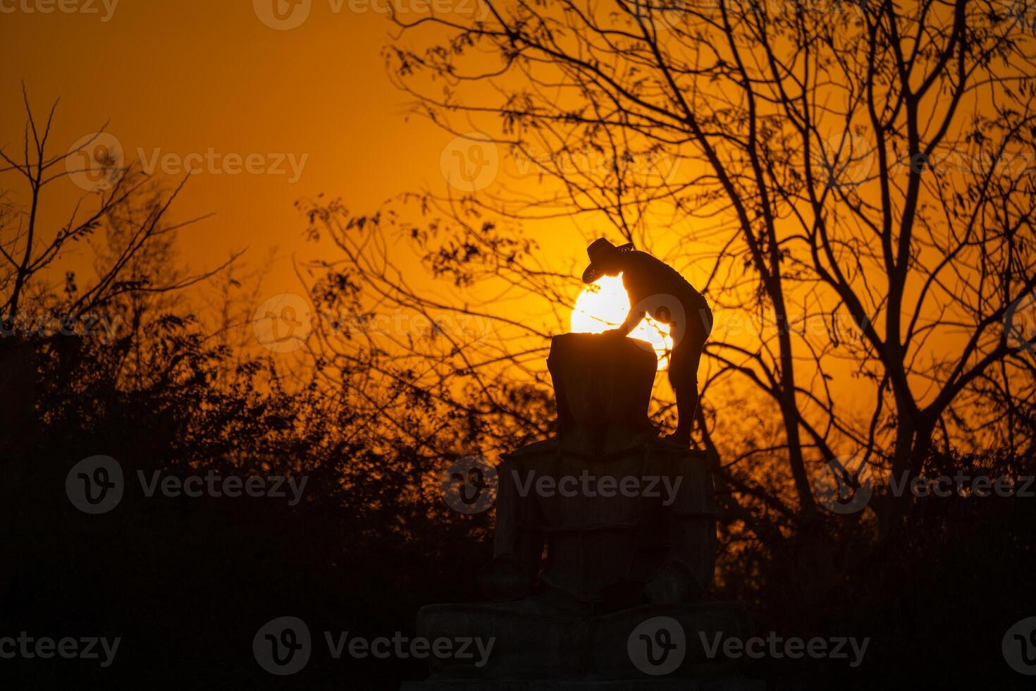 Silhouette Buddha statue and Asian worker, he is working and casting Buddha statue at twilight sunset background. Thailand. photo