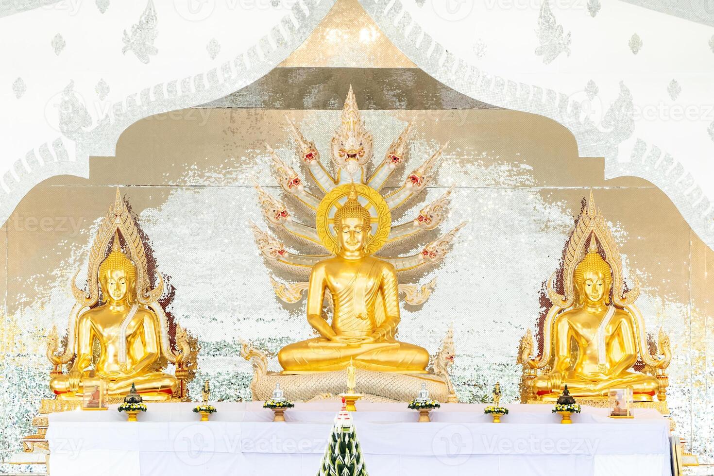 Naga Prok Buddha image sitting cross legs with legs locked together and having a King of Nagas behind it. photo