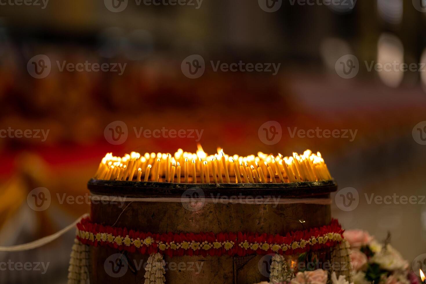 lighted candles laid out in circle in the dark with small white shadow on the right side of the background. photo