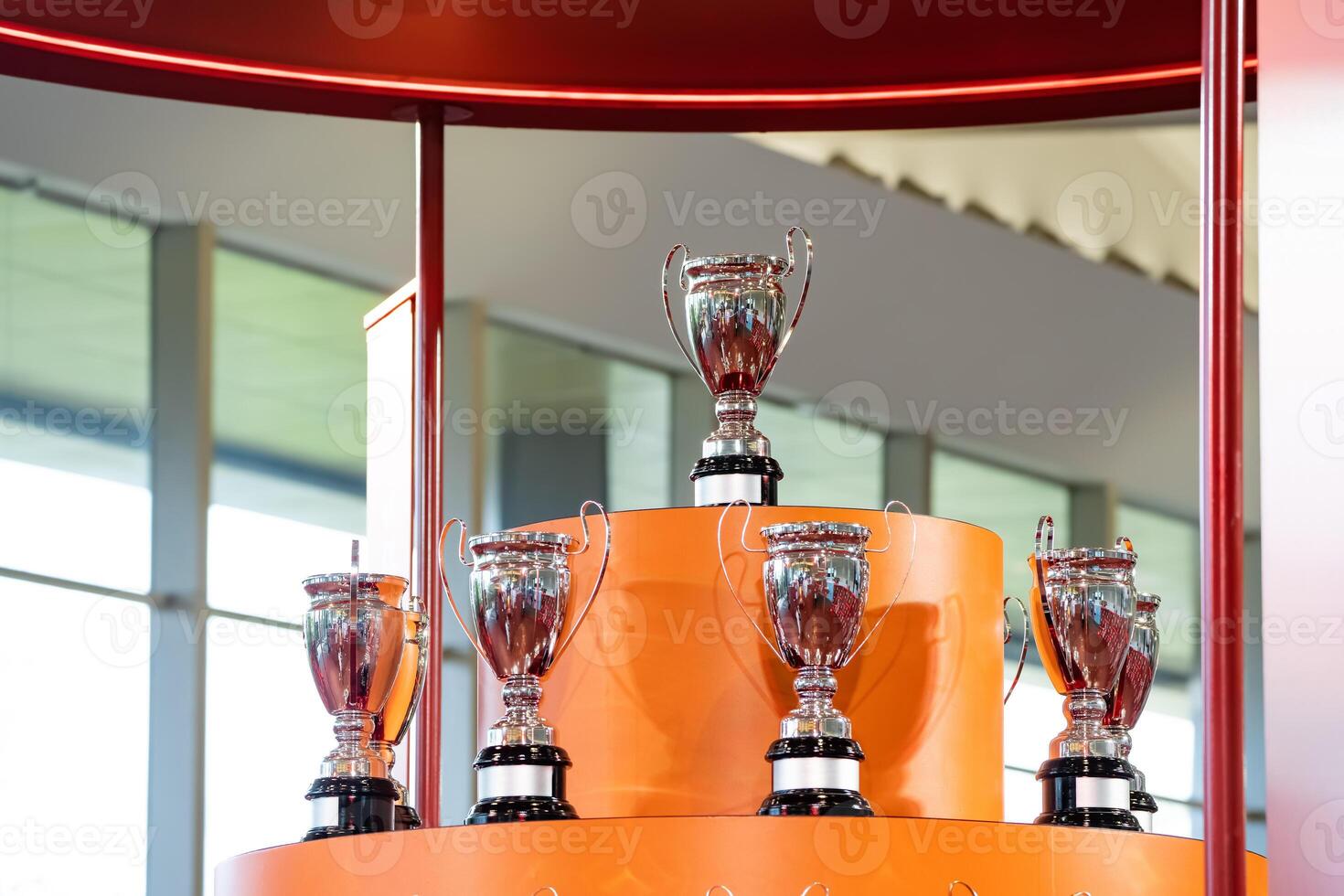 The silver trophies on the orange stage to the winners of the competition stand majestically. A light shone from the window, hitting the trophy. photo